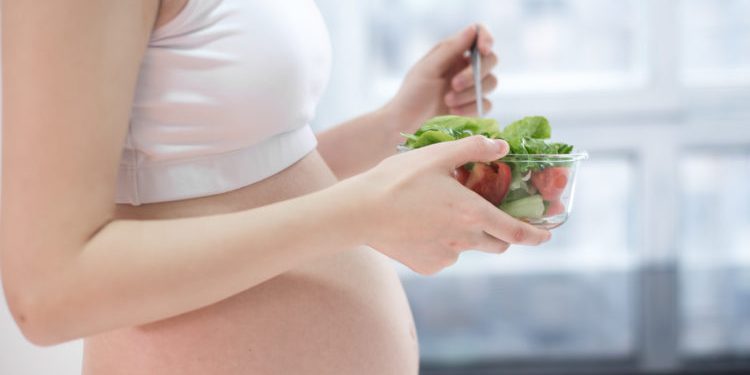healthy nutrition and pregnancy. pregnant woman's belly and vegetable salad